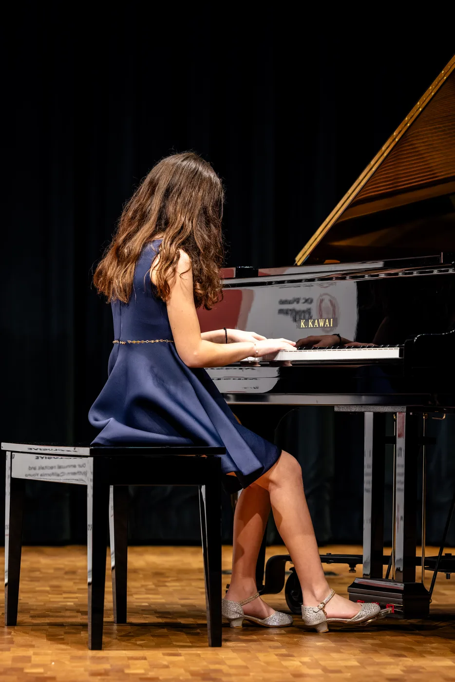 An OC Piano Program student performing at the grand piano on the recital stage